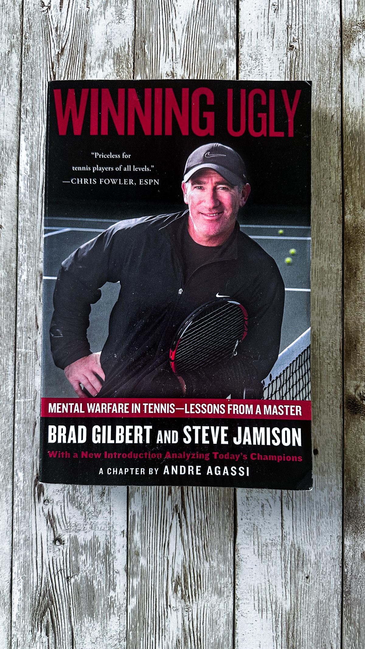 A book on a wood board. Book is called Winning Ugly by Brad Gilbert.